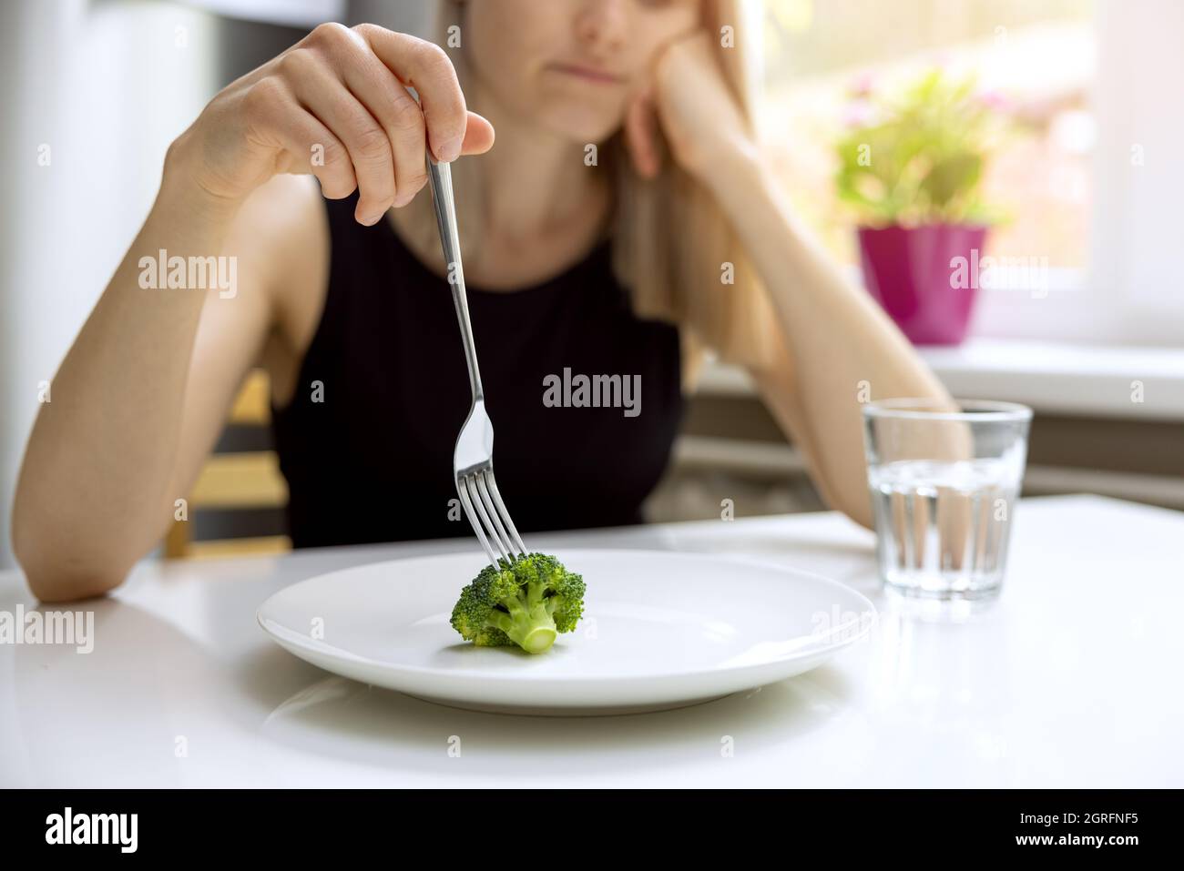 problemi di dieta, disturbi alimentari - donna infelice guardando la piccola porzione di broccoli sul piatto Foto Stock