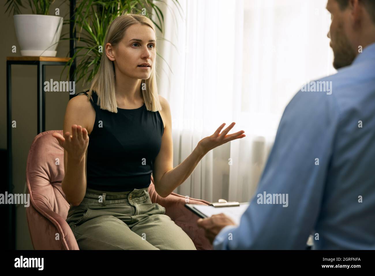 psicoterapia - psicoterapeuta maschile o psichiatra che conduce consulenza con la giovane donna Foto Stock