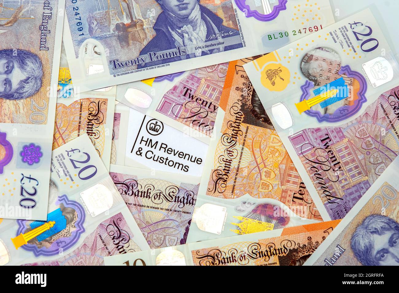 HM Revenue e documento doganale sotto una pila di banconote del Regno Unito Foto Stock