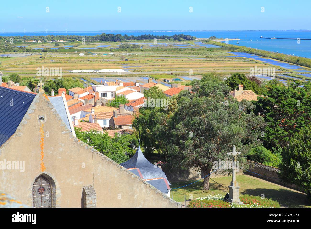 Francia, Vandea, Noirmoutier Island, Noirmoutier en l'ile, chiesa di Saint Philbert e paludi di sale sullo sfondo Foto Stock