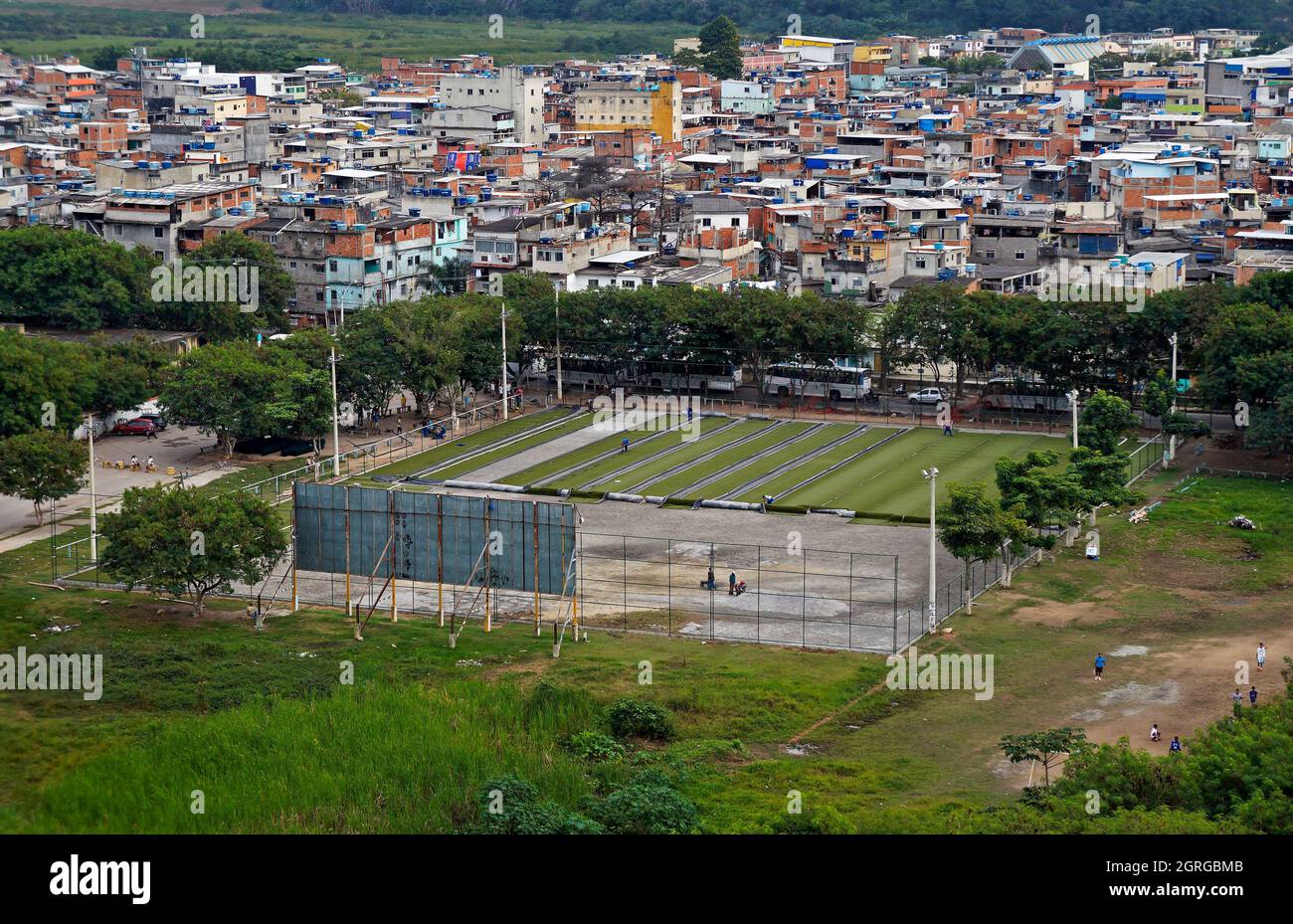 RIO DE JANEIRO, BRASILE - 6 GIUGNO 2014: Applicazione di erba sintetica su un campo di calcio in favela (Rio das Pedras) Foto Stock
