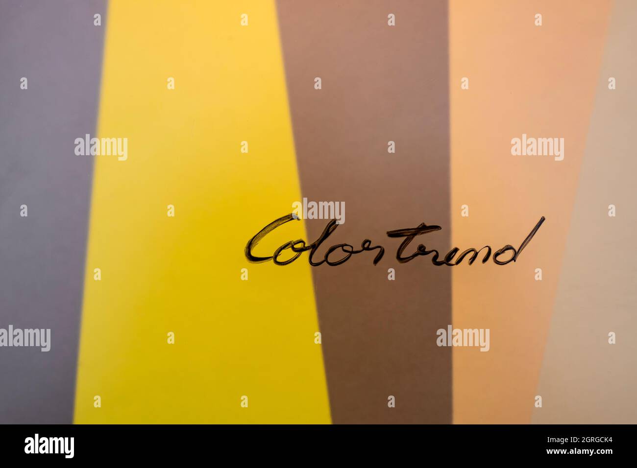 Tendenza colore scritto a mano su vetro colorato con colori di tendenza sfocati sullo sfondo Foto Stock