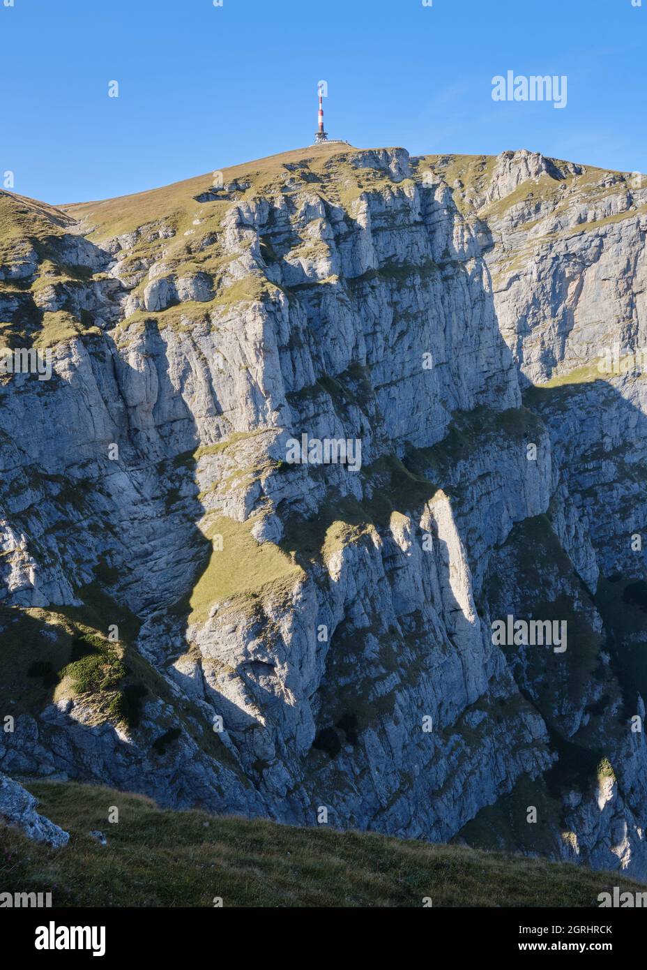 Valle Bianca (Valea Alba in rumeno) pareti rocciose verticali e relè radio Costila in cima, una popolare località alpina di arrampicata sui monti Bucegi, Roma Foto Stock