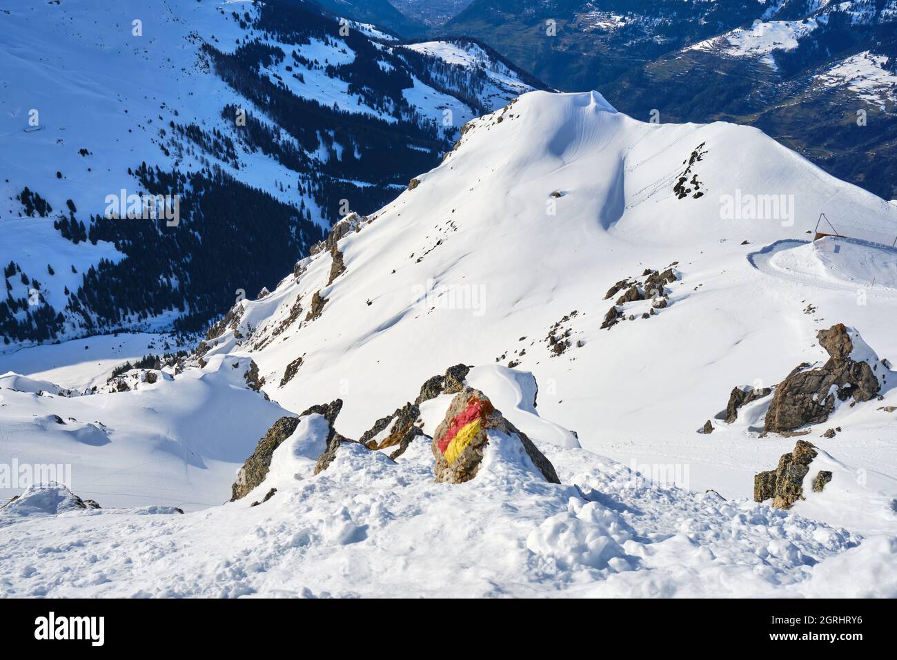 Terreno sciistico fuori pista nella località di Arosa Lenzerheide, in Svizzera, con un marcatore turistico su una roccia. Paesaggio, crinale di montagna, inverno. Foto Stock