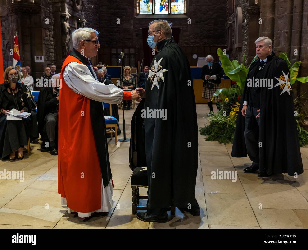 Haddington, East Lothian, Scozia, UK, 01 ottobre 2021, St John Festival: I volontari dell'Ordine stanziano fondi per fornire defibrillatori, addestramento alla RCP e trasporto dei pazienti in Scozia. Nella foto: Il reverendo William Paterson viene investito come Cavaliere nell'Ordine. I membri senior dell'Ordine indossano abiti neri con stelle bianche Foto Stock