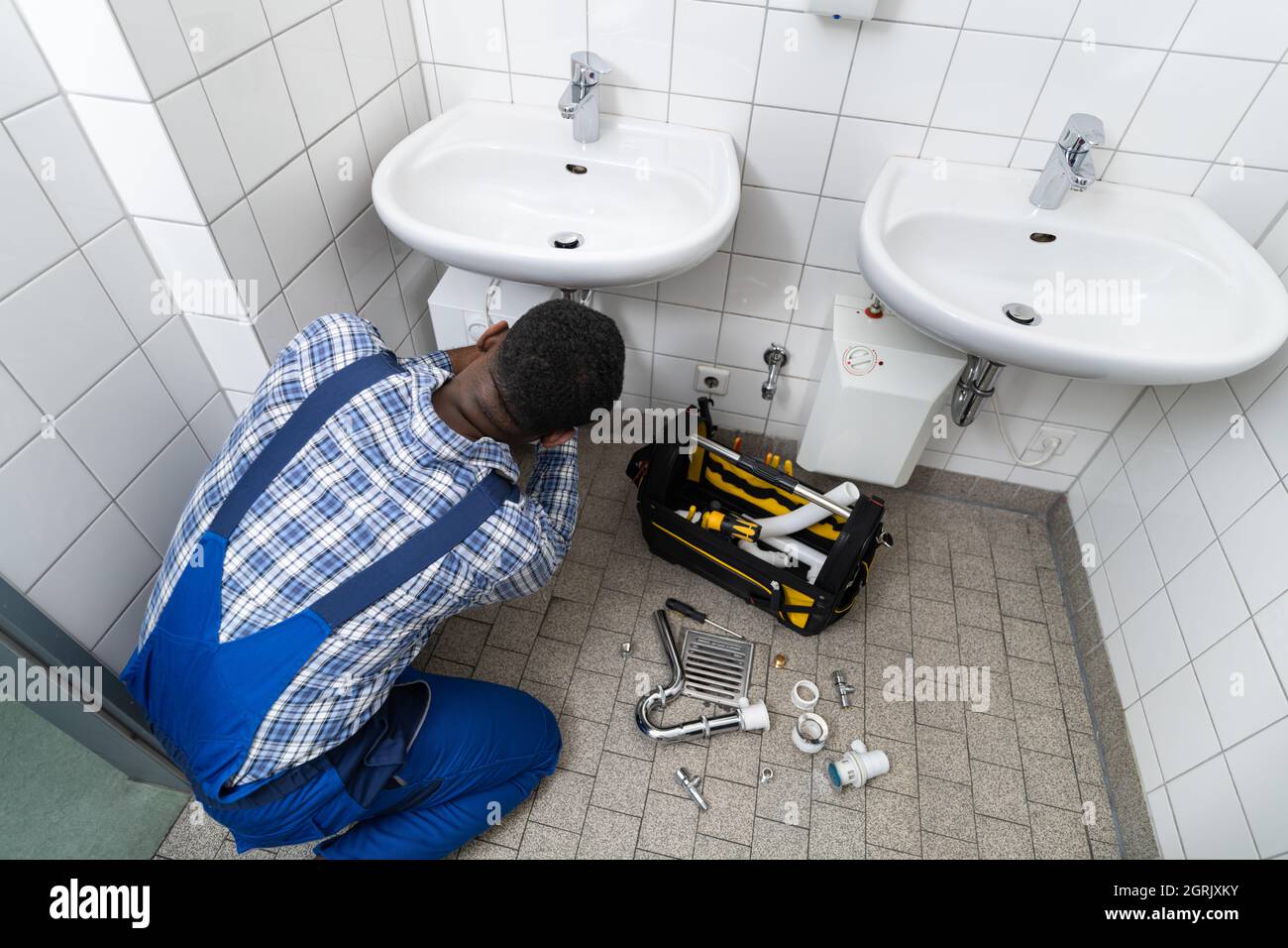 Tubo di fissaggio idraulico in bagno. Manutenzione dell'impianto idraulico in bagno Foto Stock