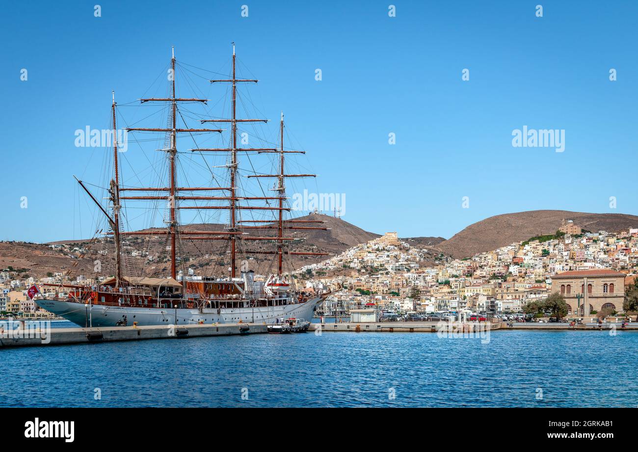 Isola di Syros, Grecia - Settembre 17 2021: Il lussuoso yacht Sea Cloud ormeggiato al porto, con Ermoupolis e Ano Syros sullo sfondo. Foto Stock