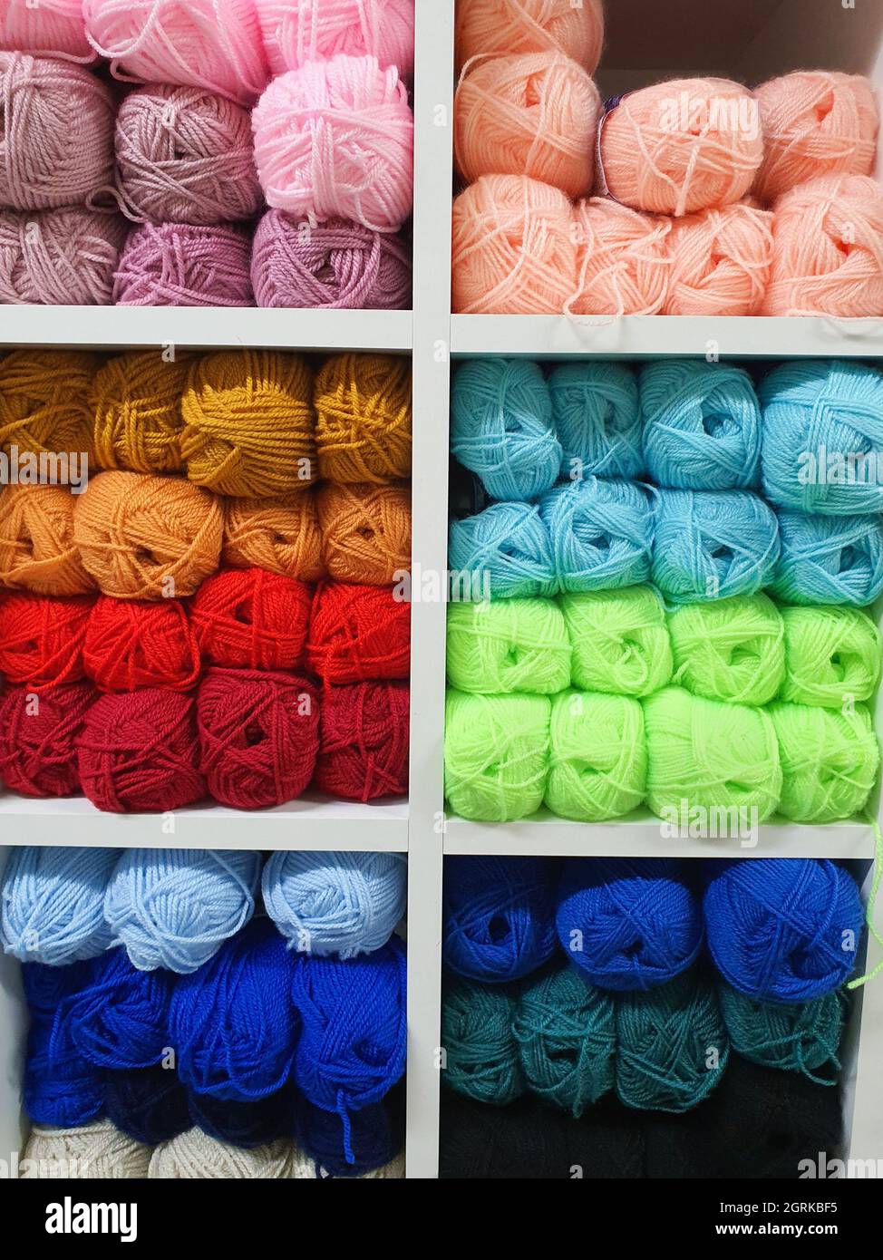 Filati colorati di lana per maglieria su scaffali in haberdashery shop. Concetto artigianale di lavorazione a maglia Foto Stock