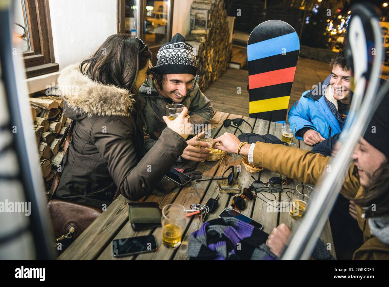 Amici felici che bevono birra e mangiano patatine all'Apres Ski - concetto di amicizia con gente allegra che si diverte al bar ristorante resort Foto Stock