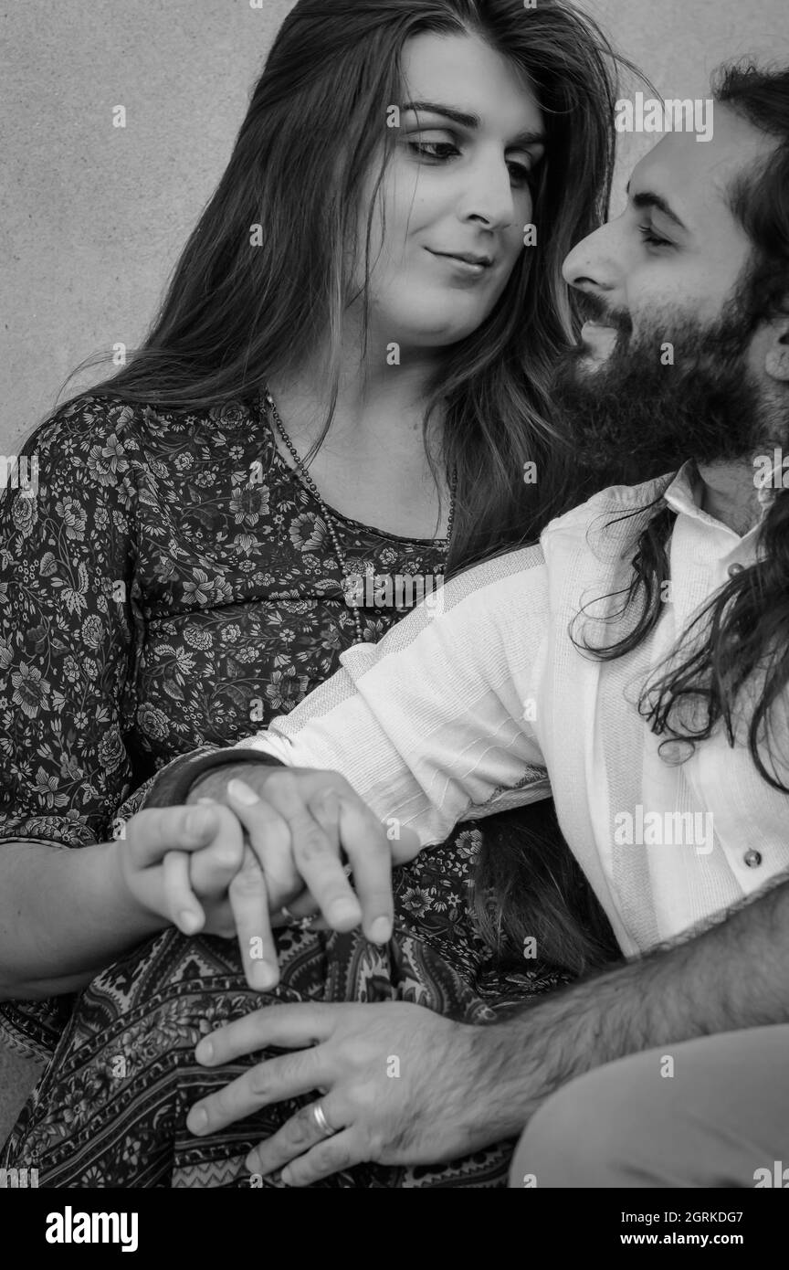 Ritratto in bianco e nero di una giovane coppia che abbraccia le mani in un momento di complicità Foto Stock