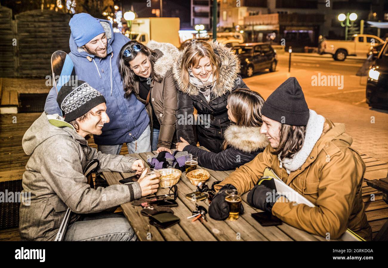 Amici felici che bevono birra e mangiano patatine al bar After ski - concetto di amicizia con gente allegra che si diverte al resort ristorante chalet Foto Stock
