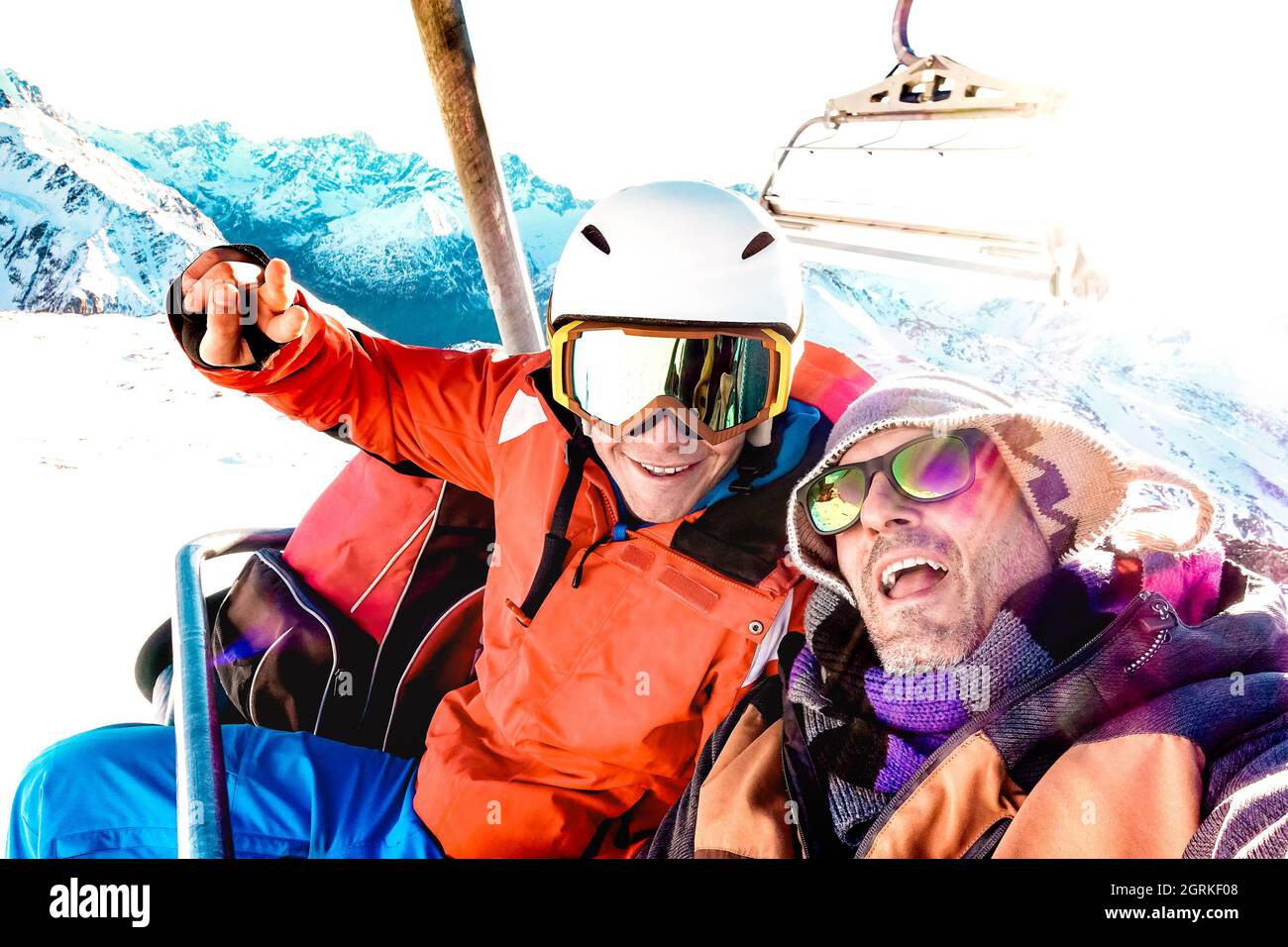 I migliori amici divertirsi a prendere selfie in seggiovia con attrezzatura da snowboard sulla stazione sciistica di montagna - concetto di amicizia invernale con i giovani Foto Stock