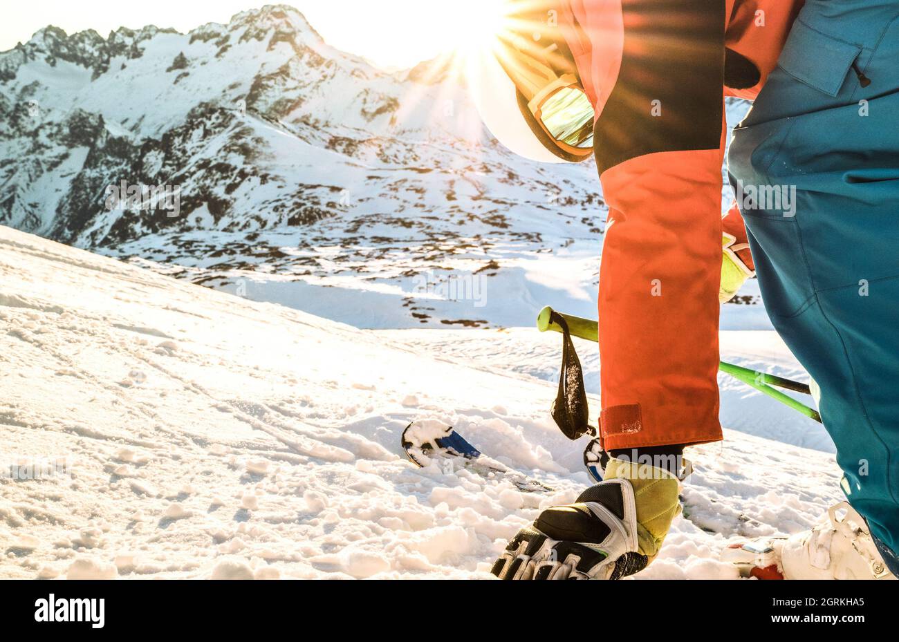 Sciatore professionista al tramonto che tocca la neve in un momento di relax nella stazione sciistica delle alpi francesi - concetto di sport invernale con ragazzo avventura in cima alla montagna Foto Stock