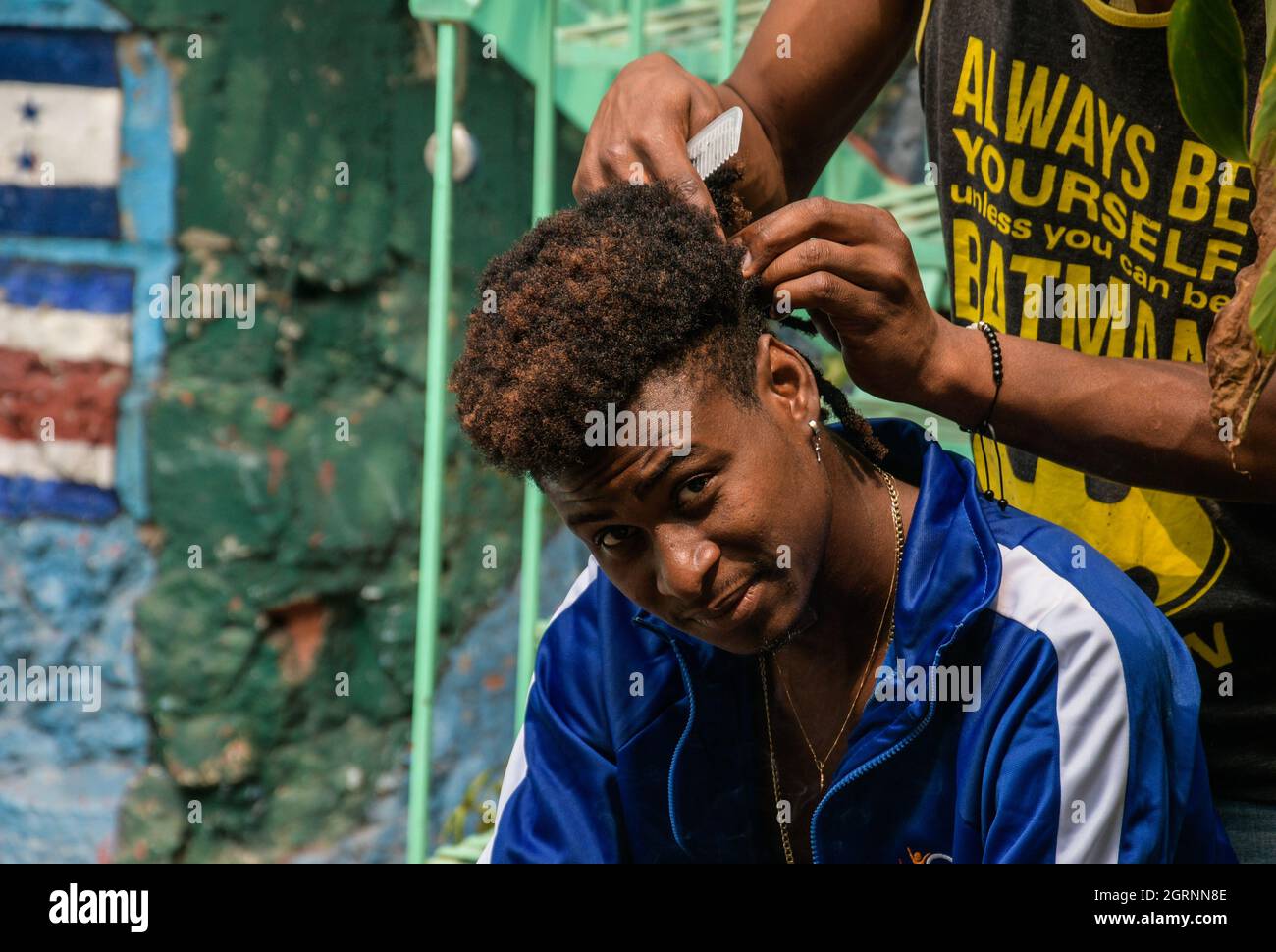 Non esclusiva: CITTÀ DEL MESSICO, MESSICO - 29 SETTEMBRE 2021: Un migrante haitiano è aiutato da un altro migrante a fare le trecce nei suoi capelli durante il loro soggiorno Foto Stock