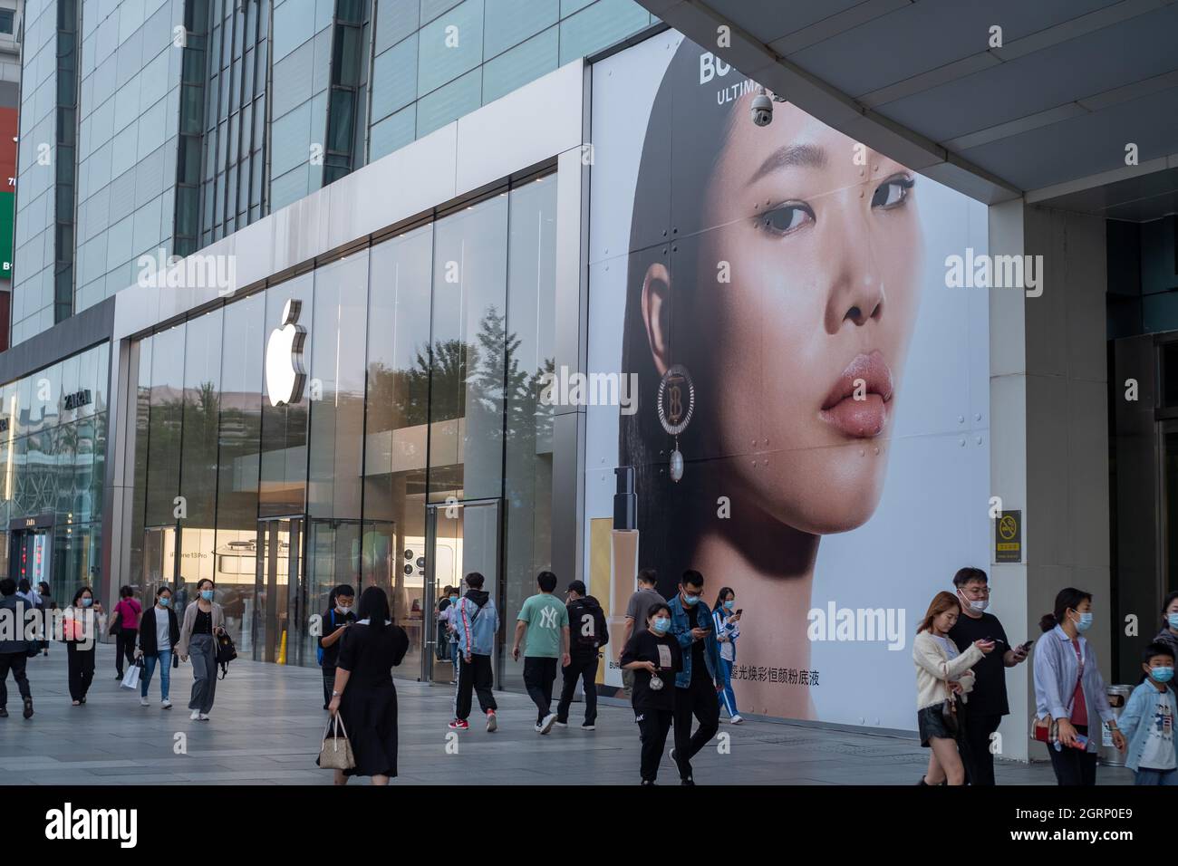 I consumatori cinesi camminano oltre l'etichetta di moda britannica Burberry ad vicino ad un negozio Apple a Pechino, Cina.01-Ott-2021 Foto Stock