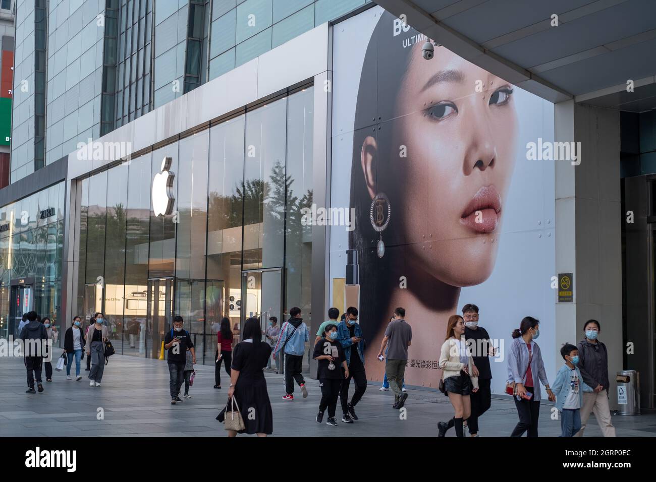I consumatori cinesi camminano oltre l'etichetta di moda britannica Burberry ad vicino ad un negozio Apple a Pechino, Cina.01-Ott-2021 Foto Stock
