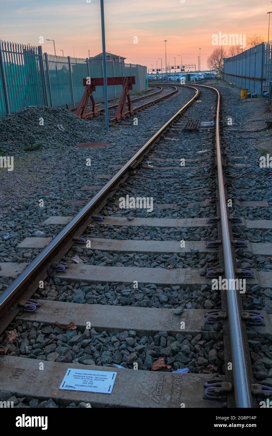 Linea ferroviaria che conduce al porto di Southampton Inghilterra con tramonto rosso arancione serale Foto Stock