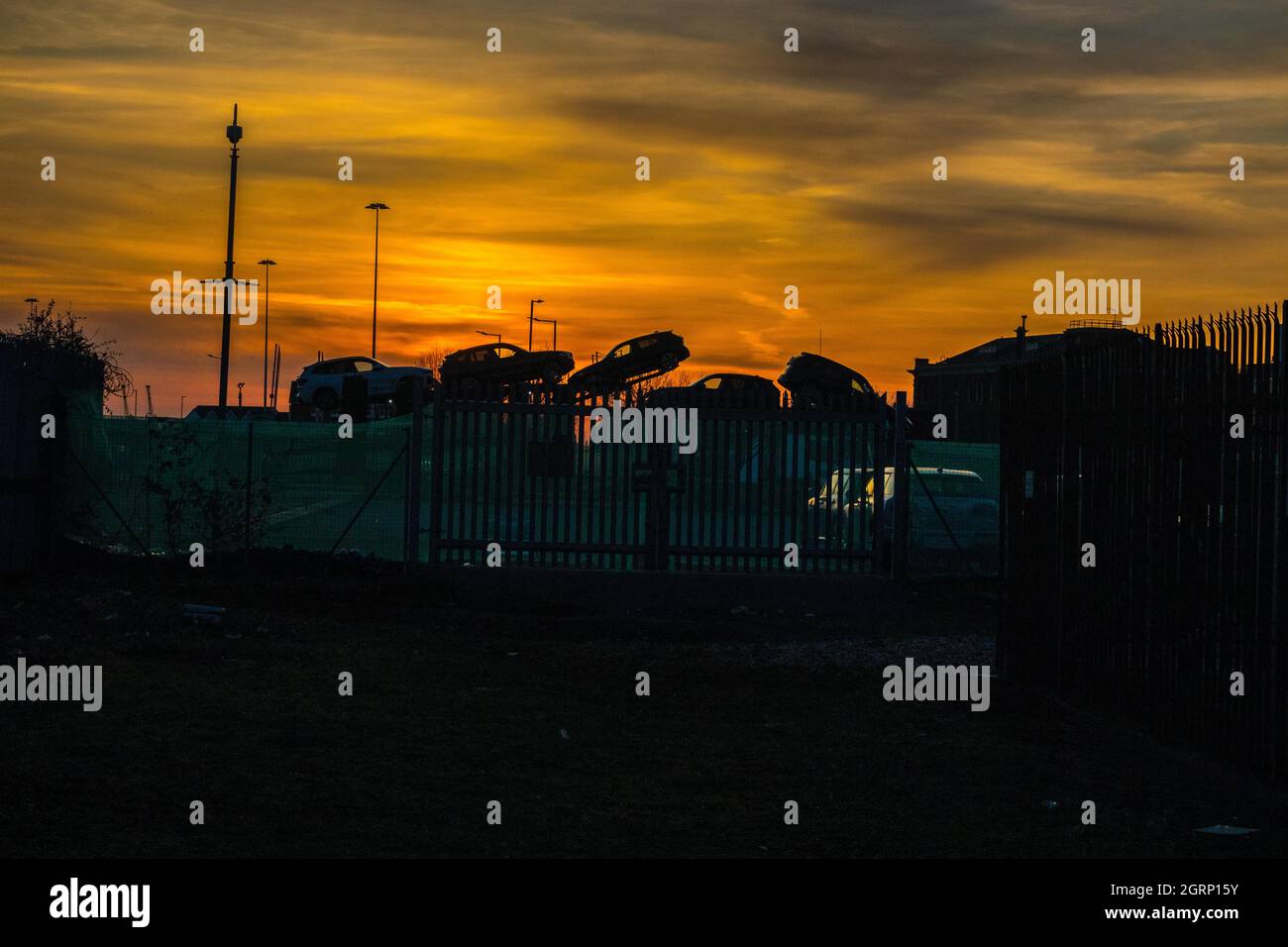 Tramonto rosso contro immagini di sagome con le auto sul trasportatore a Southampton ormeggia in Inghilterra. Southampton è il più grande porto di movimentazione veicoli del Regno Unito. Foto Stock