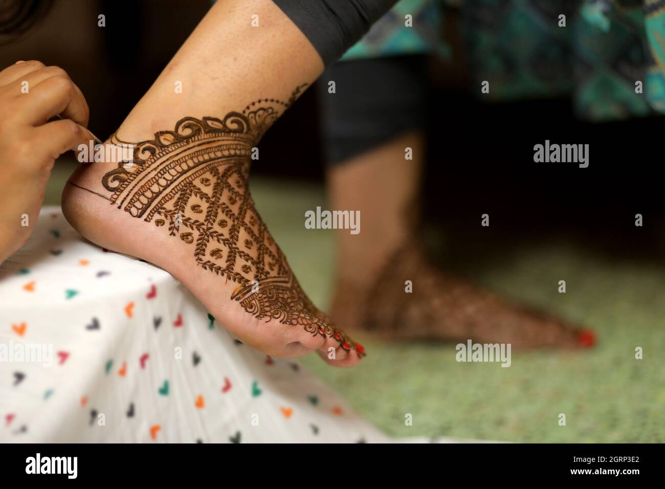 Vista ravvicinata della sposa con henné su entrambe le mani su sfondo scuro e sbiadito Foto Stock