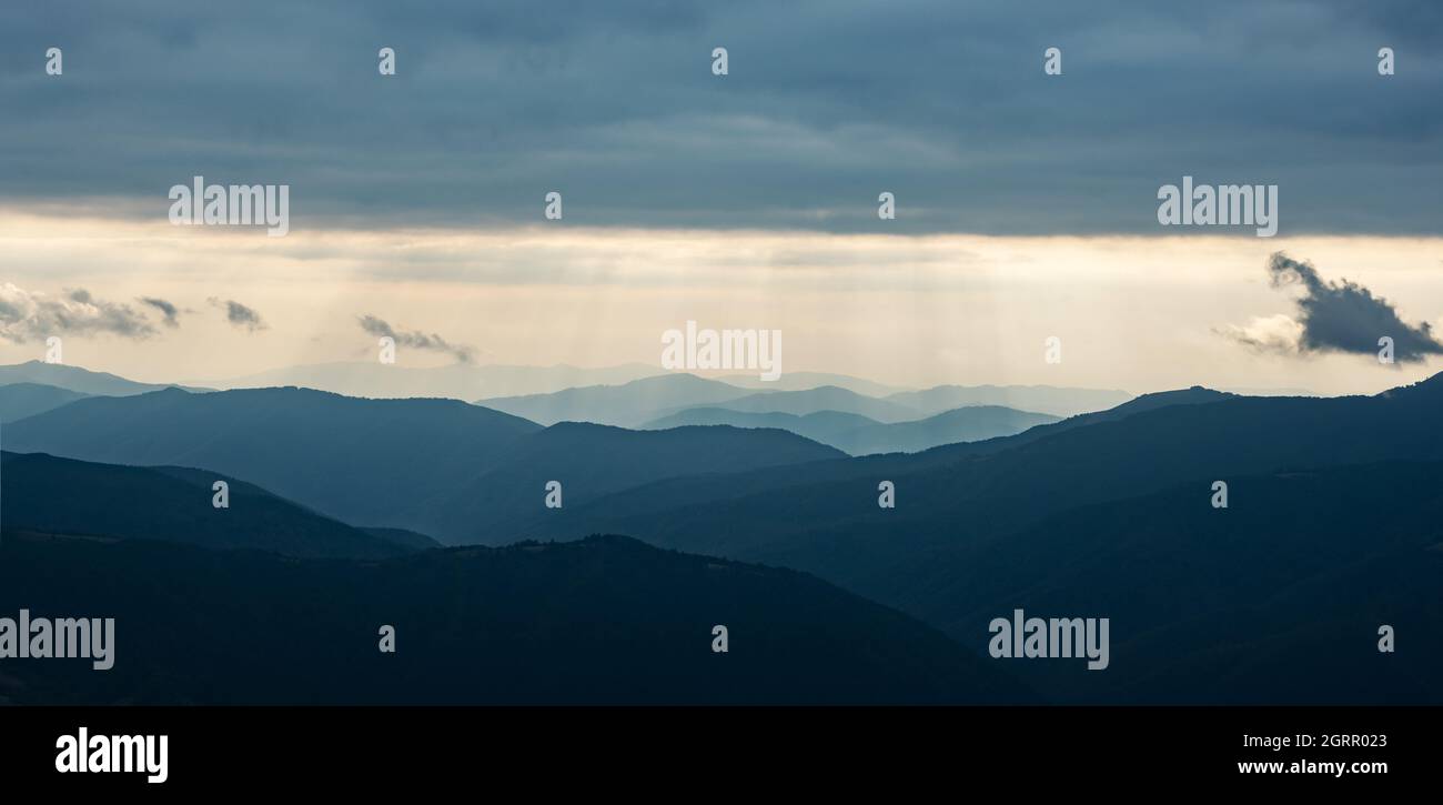 Luce del giorno nelle montagne primaverili. Bellissimi raggi di sole sullo sfondo. Panorama. Fotografia di paesaggio Foto Stock