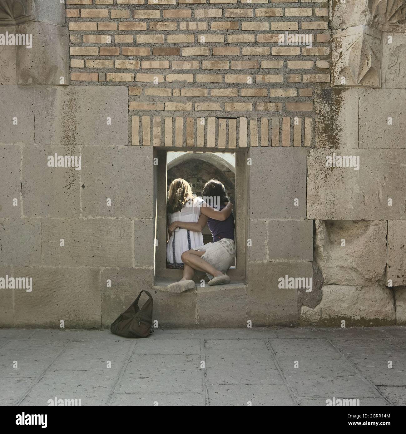 Un souvenir fotografico in Turchia due donne che posano per essere fotografate dalla finestra di 'scit' (stanza di preghiera) nel cortile del caravansar Sultanhani Foto Stock