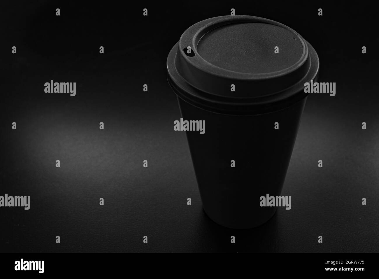 Tazza in plastica monouso con coperchio in un ambiente scuro e suggestivo Foto Stock