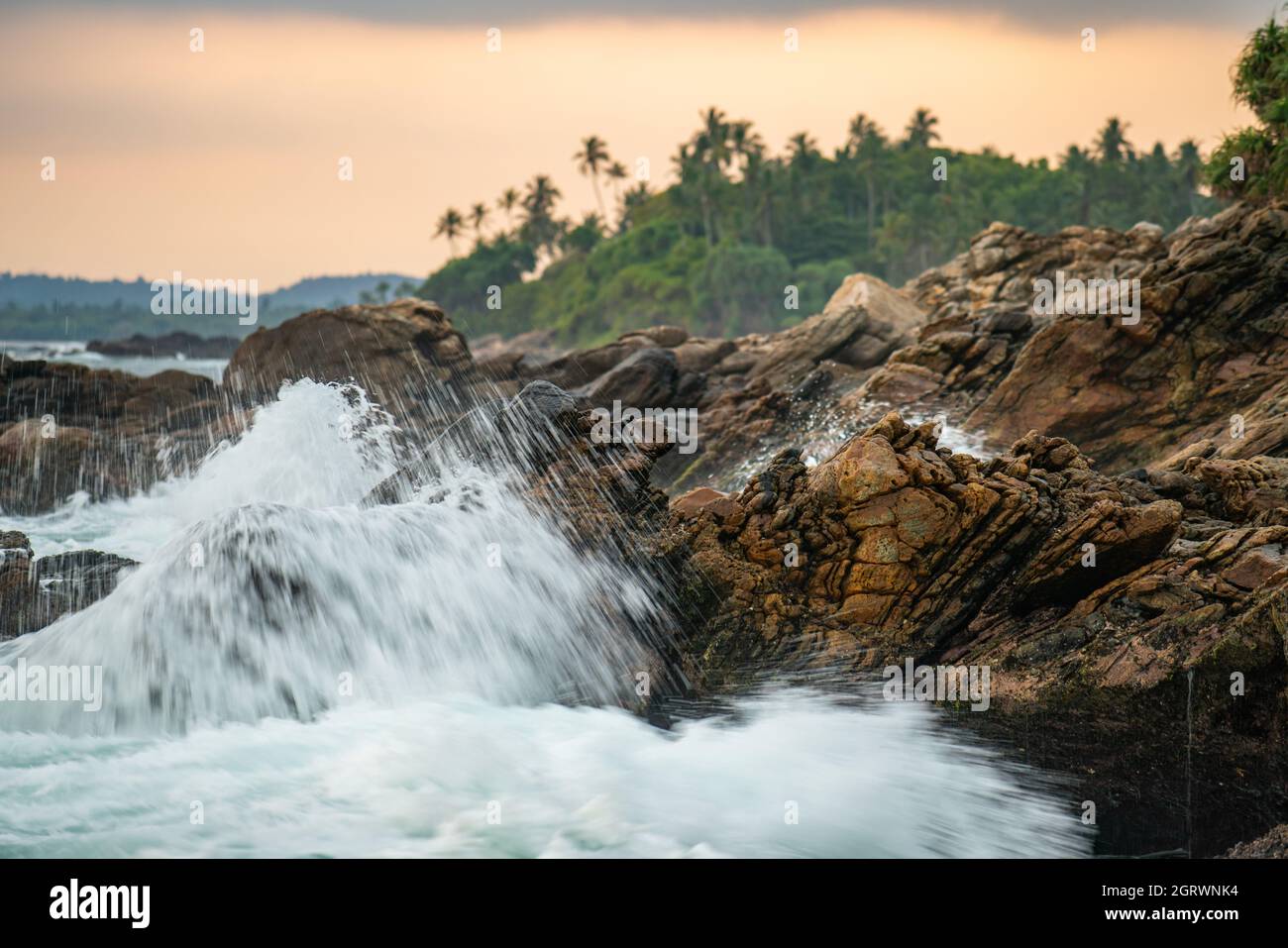 Bellissimo tramonto colorato sul mare e massi sulle isole dello Sri Lanka. Foto Stock