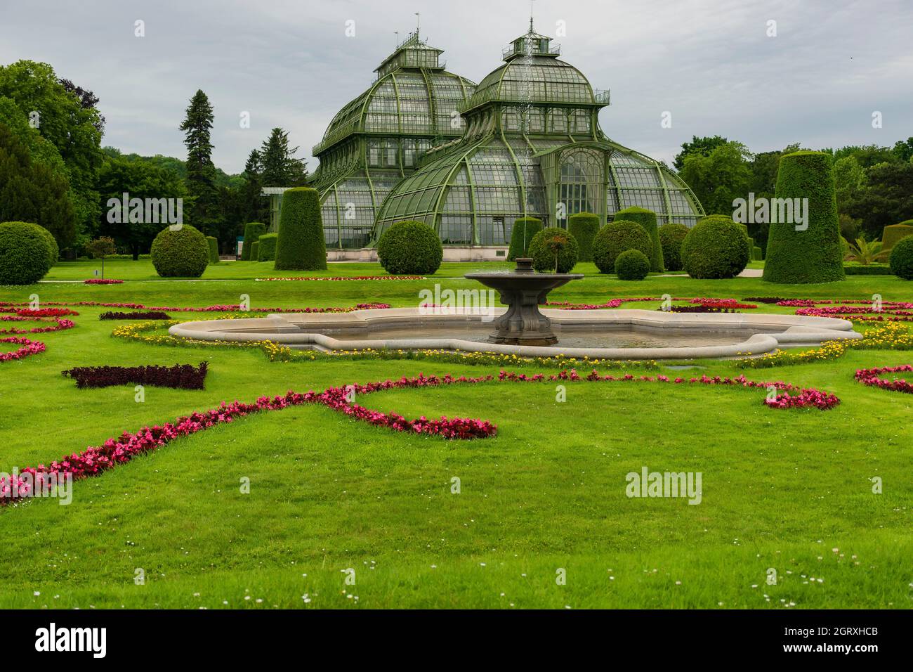 31 maggio 2019 Vienna, Austria - Palmenhaus nei giardini di Schonbrunn. (Casa di palme) costruito di ferro e vetro. Prati in ordine e giorno nuvoloso Foto Stock