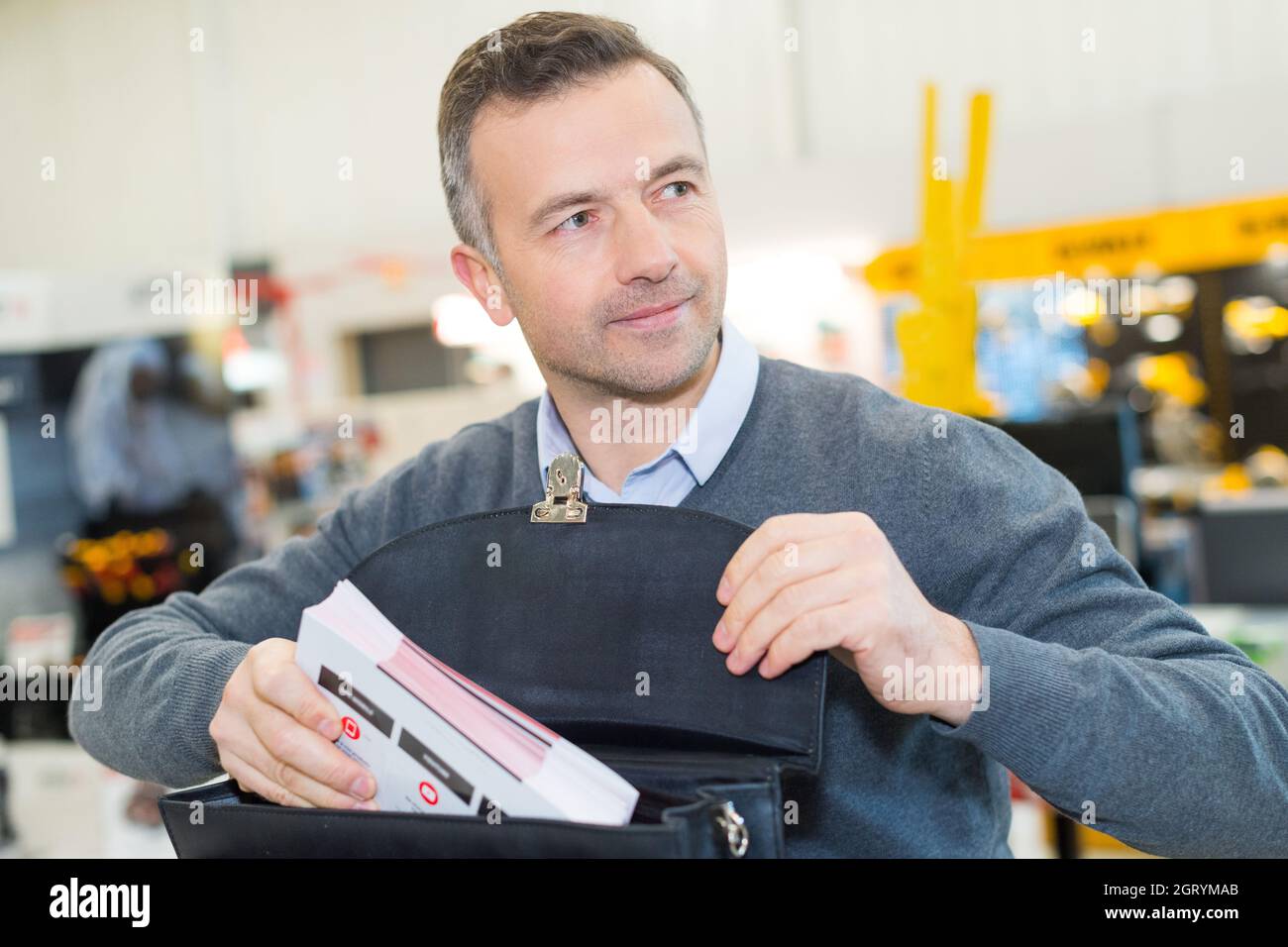 businessman che mette il white paper in un documento di archivio blu Foto Stock