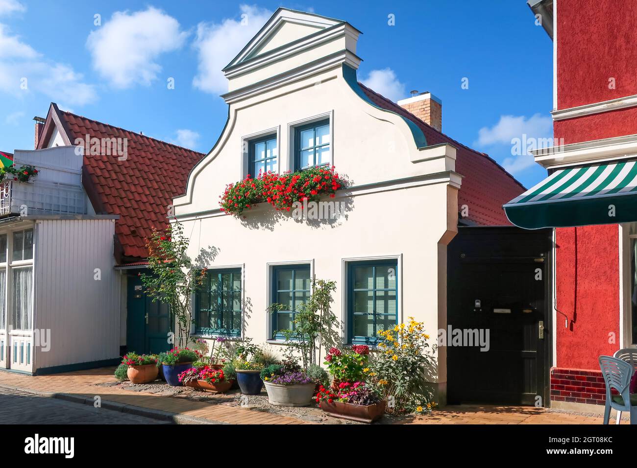 Un tipico villaggio tedesco casa con fiori di fronte al centro storico di Warnemunde Rostock, Germania, una città costiera sul Mar Baltico. Foto Stock
