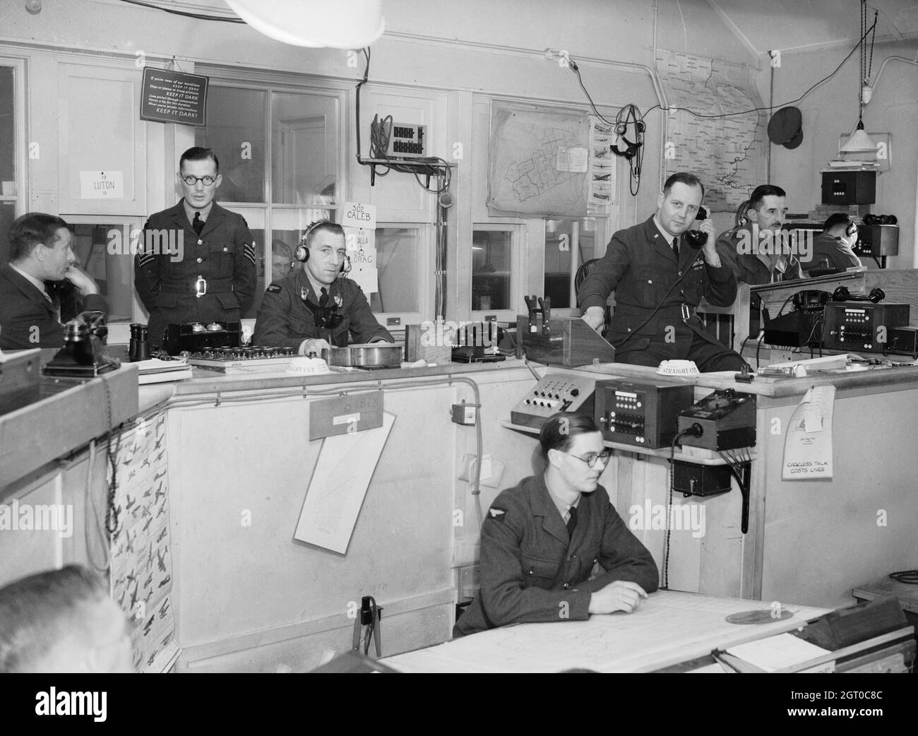 Interno del settore 'G' Operations Room a Duxford, Cambridgeshire. I richiami di squadroni da caccia controllati da questo settore possono essere visti sul muro dietro l'operatore seduto terzo da sinistra. Il Controller è seduto quinto da sinistra, e all'estrema destra, dietro l'ufficiale di collegamento dell'esercito, sono gli operatori R/T in diretto contatto con l'aeromobile. Foto Stock