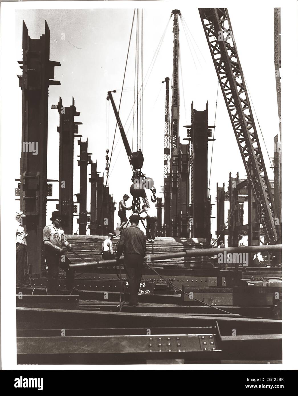 EMPIRE STATE BUILDING NY, NY 1930 - 1931. Viste generali e dettagliate dell'Empire state Building in costruzione che mostrano i lavoratori che svolgono varie attività, tra cui posizionamento, saldatura e rivettatura dell'acciaio, sollevamento di materiali e forniture, funzionamento e riparazione di macchinari. Ci sono anche vedute a volo d'uccello del centro di Manhattan che mostrano altri edifici in costruzione. Fotografie di: Hine, Lewis Wickes, 1874-1940 . Foto Stock