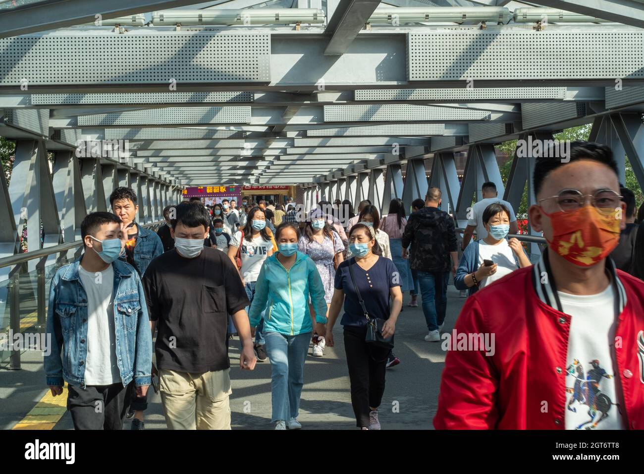 La gente cammina su un cavalcavia nel quartiere degli affari di Xidan a Pechino, Cina. 02 ottobre 2021 Foto Stock