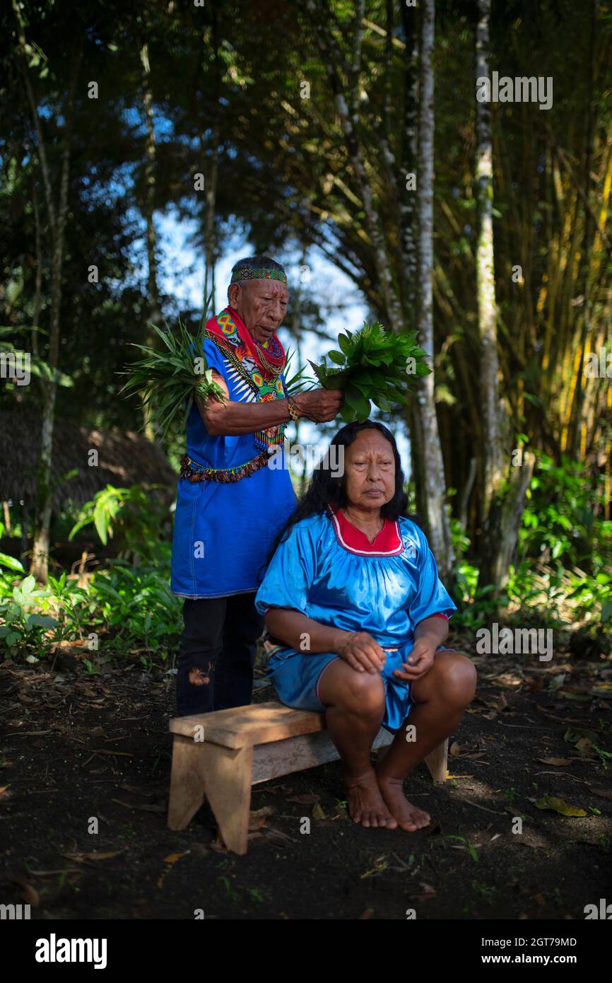 Nueva Loja, Sucumbios / Ecuador - 2 settembre 2020: Sciamano indigeno anziano di nazionalità Cofan che esegue un rituale di guarigione ad una donna Cofan nella A Foto Stock