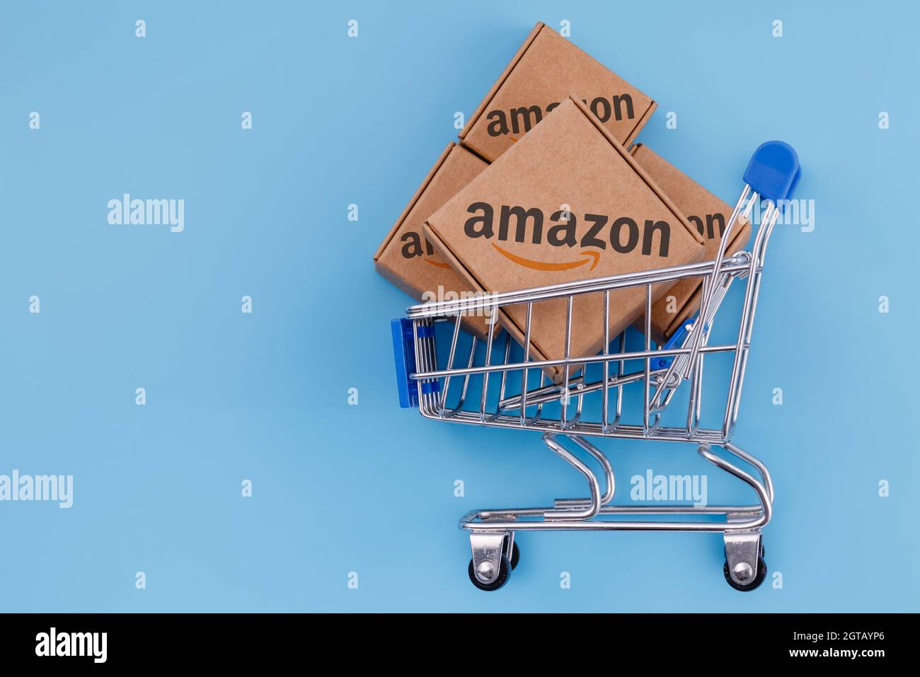 Foto modificata del pacco con logo Amazon nel carrello su sfondo blu Foto  stock - Alamy