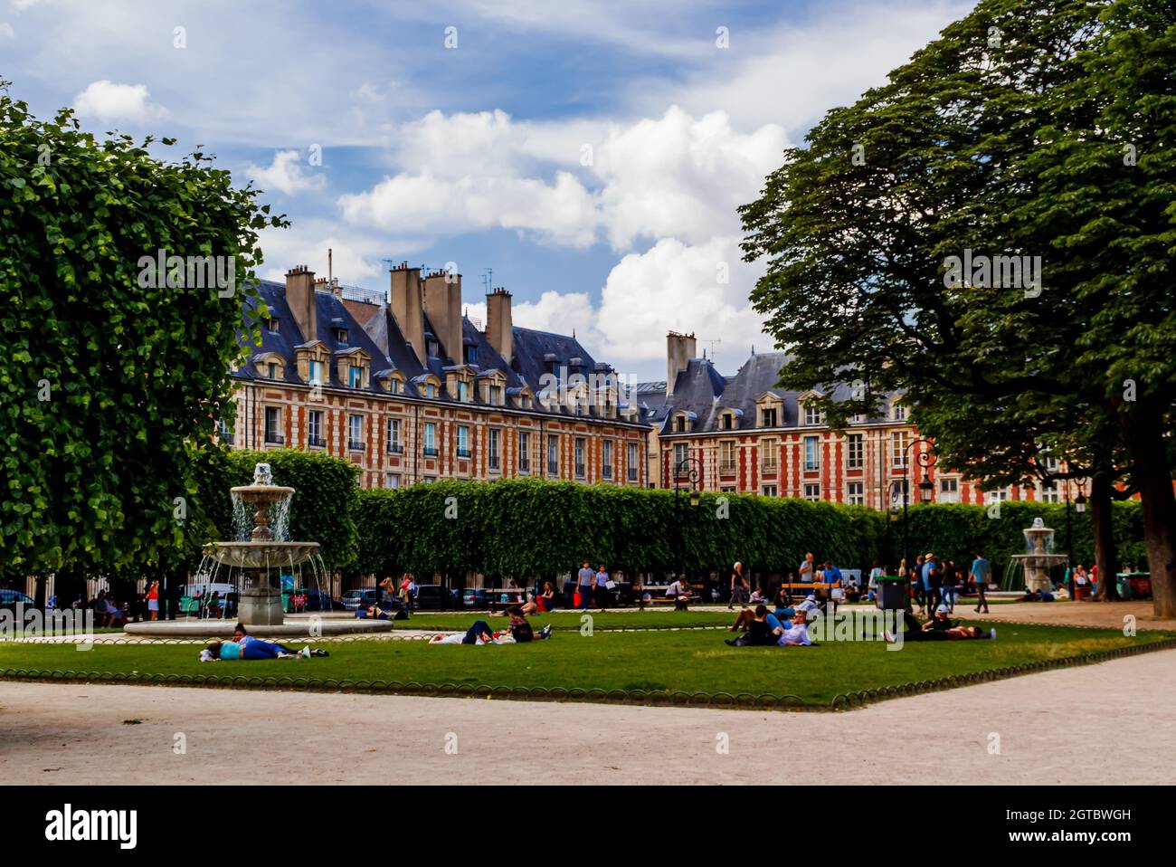 Parigi, Francia - 04 giugno 2018: Persone che si rilassano sui prati verdi della famosa Place des Vosges - la più antica piazza pianificata di Parigi. Foto Stock