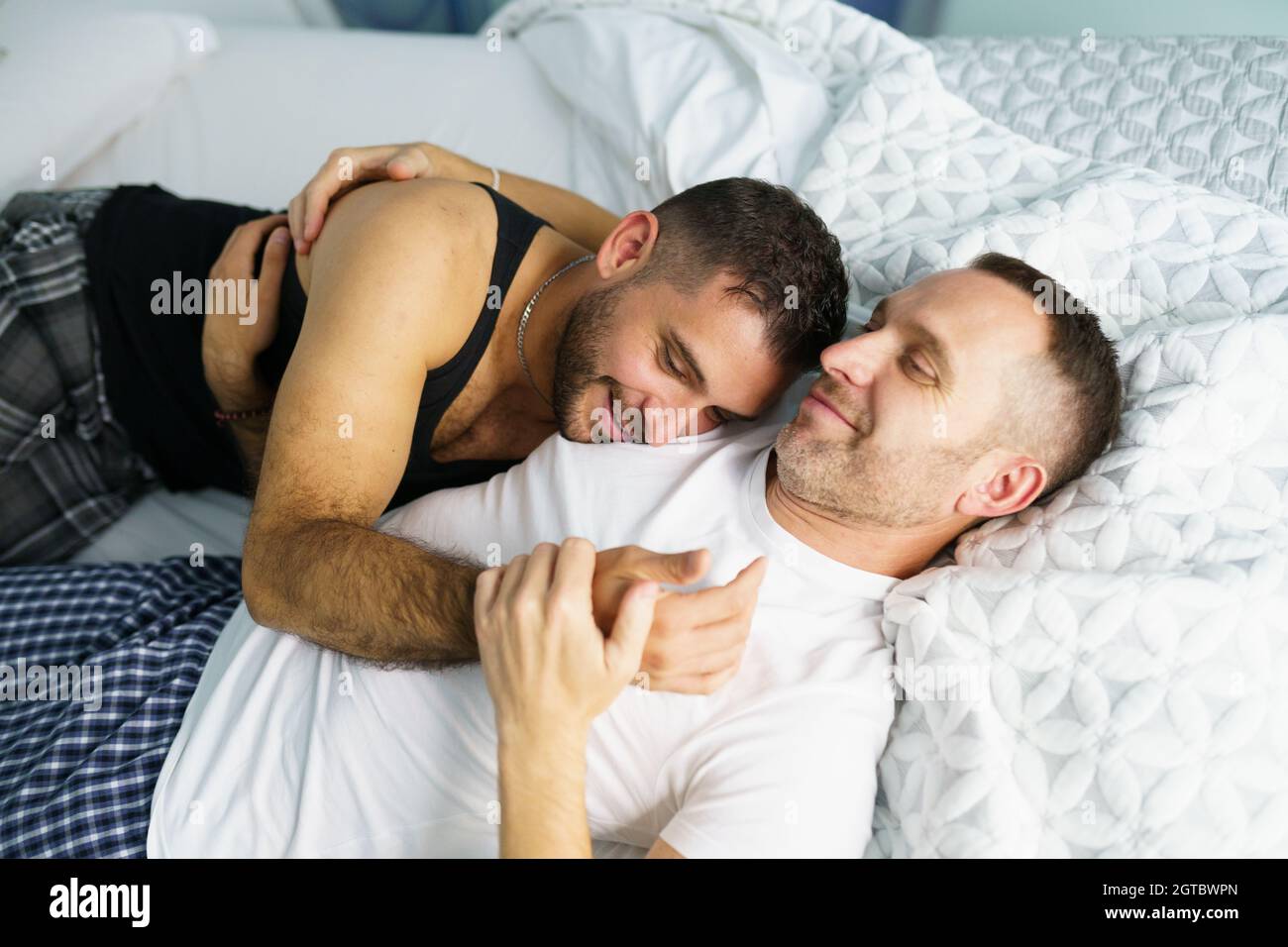 Vista ad alta angolazione di uomini gay che si abbracciano mentre si  sdraiano sul letto Foto stock - Alamy