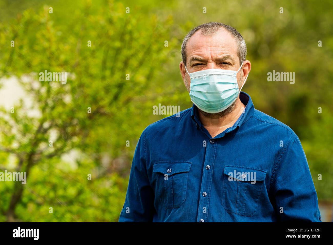 Adulto uomo allergico in Una maschera protettiva sulla natura Foto Stock