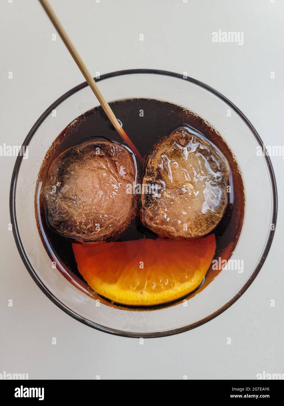 Due cubetti di ghiaccio e una fetta d'arancia in una bevanda che simboleggia un viso sorridente. Felicità, carpe diem, godere il concetto di tempi buoni Foto Stock