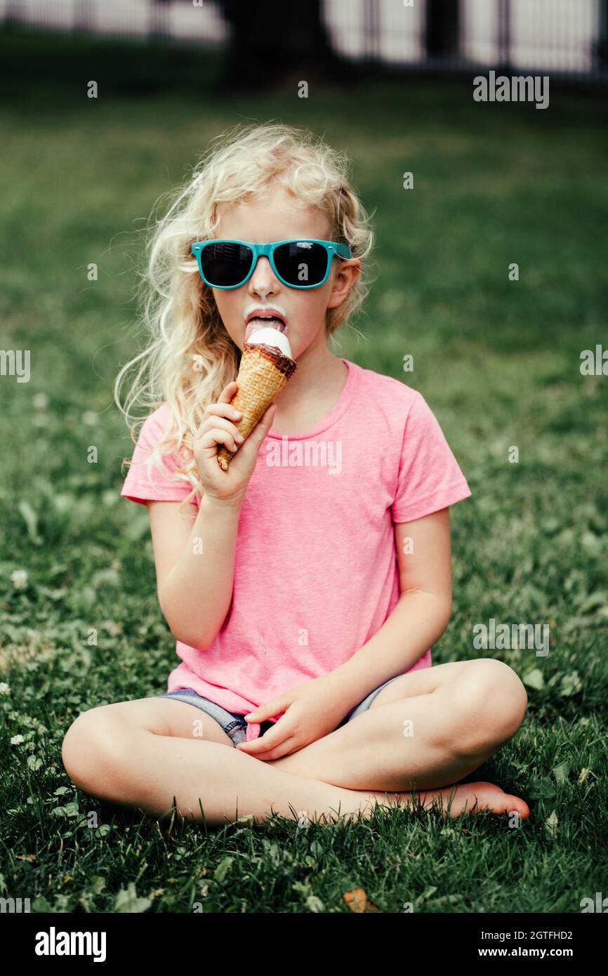 Ragazza in occhiali da sole con naso sporco e baffi mangiare gelato da  waffle Cone. Piatti di stagione Foto stock - Alamy
