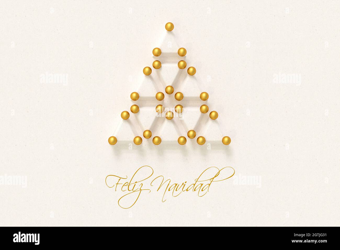 Albero di Natale fatto da triangoli di carta e baubles dorati. Messaggio spagnolo 'Feliz Navidad' (buon Natale) qui sotto. Foto Stock