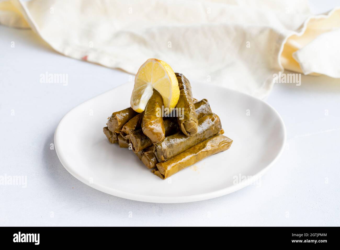 Foglie ripiene di olio d'oliva su sfondo bianco. Il gusto tradizionale della cucina turca. Nome locale zeytinyagli yaprak sarma Foto Stock