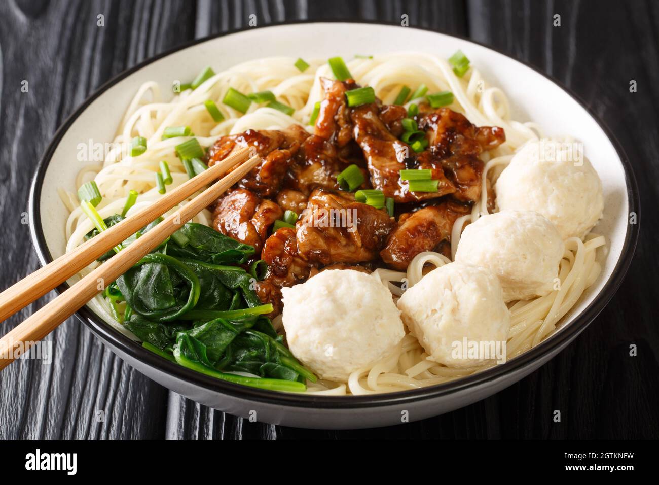 Mie Ayam Pangsit è una deliziosa ricetta indonesiana fatta in casa per tagliatelle, pollo, polpette di panino da primo piano nella ciotola sul tavolo. Orizzontale Foto Stock