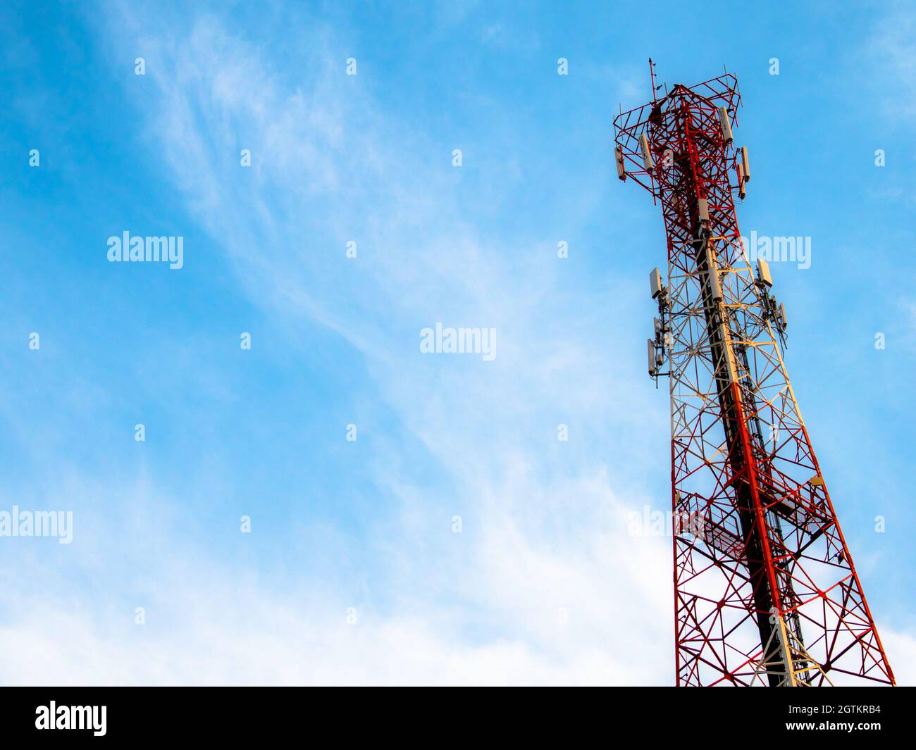 Torre di comunicazione dalla vista inferiore con sfondo cielo blu. Foto Stock