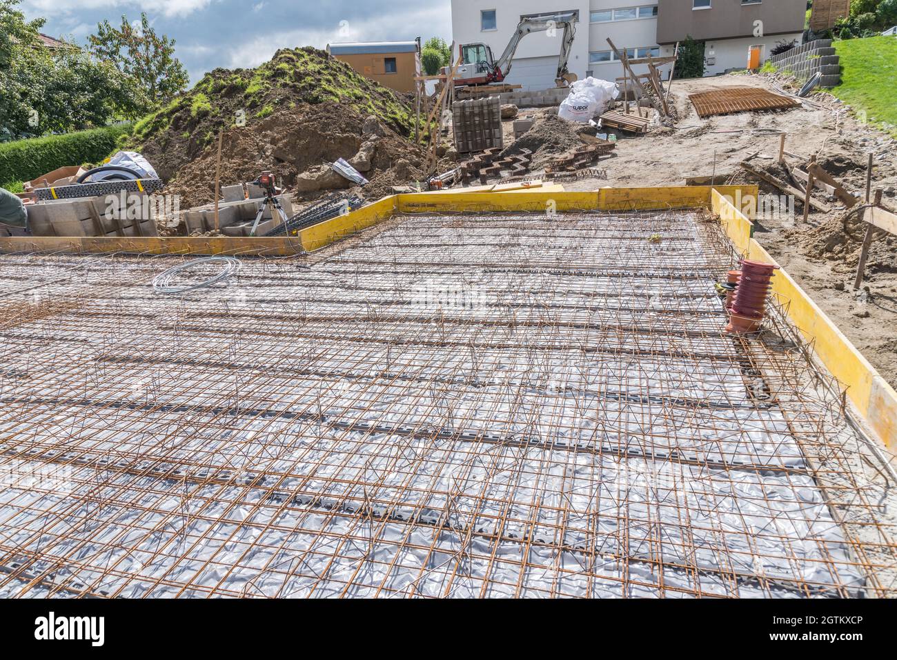 Cantiere con casseforme per fondazioni in calcestruzzo, rete in acciaio strutturale Foto Stock
