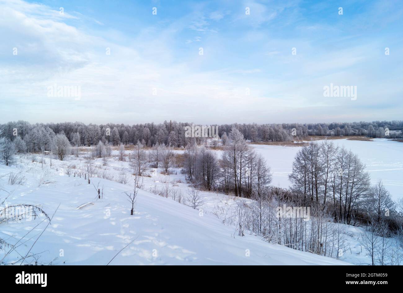 Il paesaggio invernale con terreno collinare in Russia su turn blu lo sfondo un cielo. Bella natura al giorno solare Foto Stock
