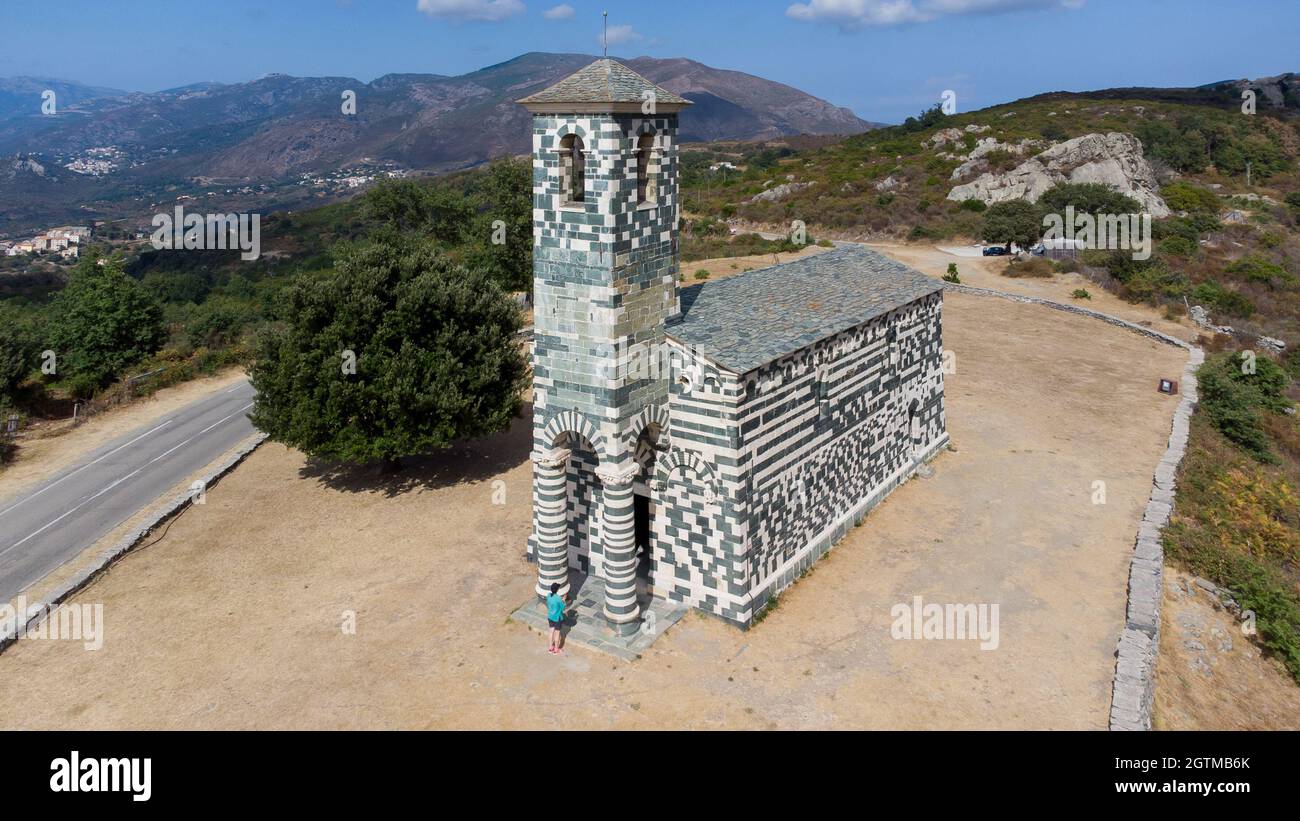 Veduta aerea della chiesa di San Michele di Murato in Corsica Settentrionale, Francia - chiesa in pietra policromica con un campanile verde e bianco nel moun Foto Stock