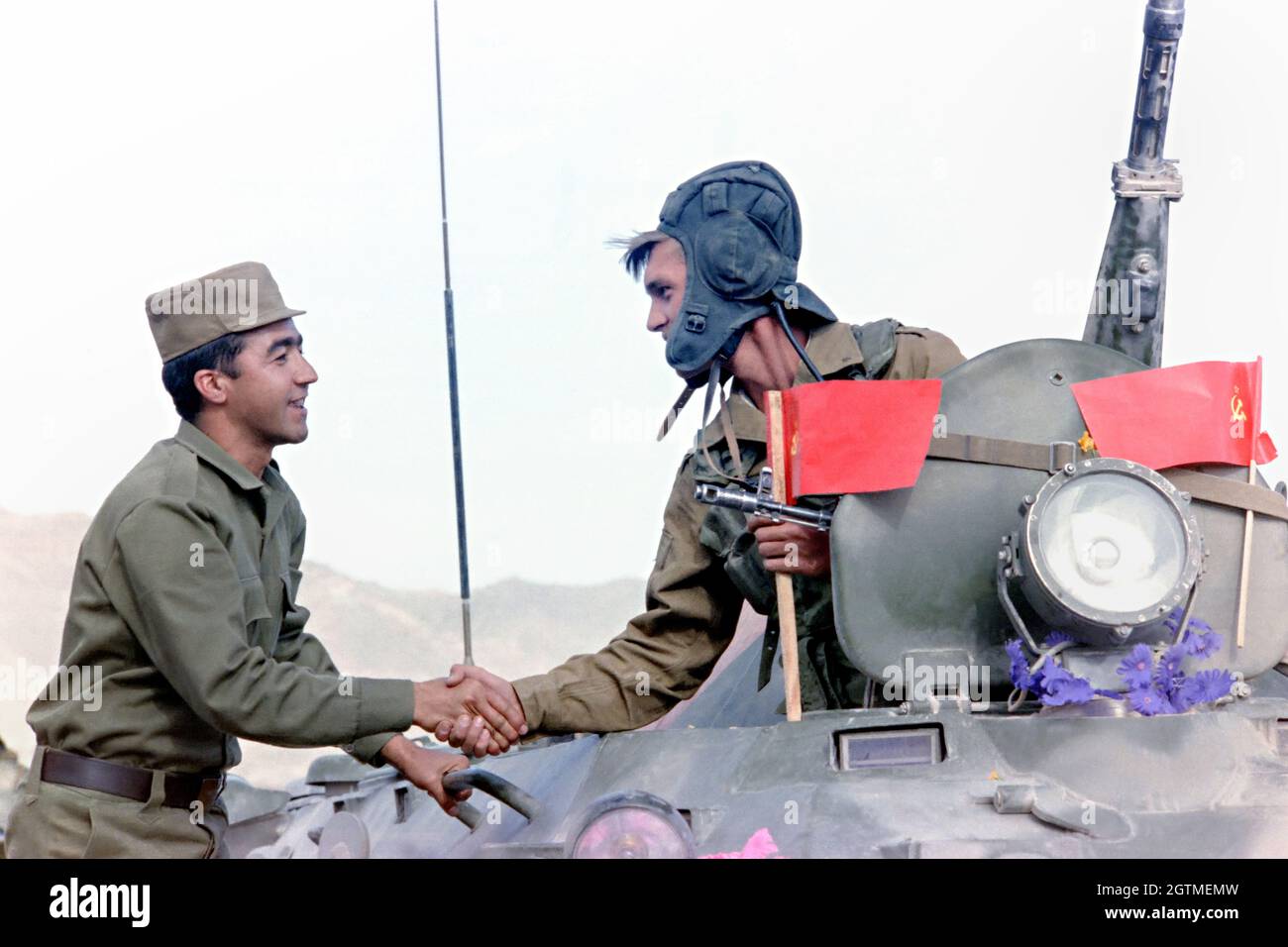 KABUL, AFGHANISTAN. 16 maggio 1988. Un soldato sovietico russo, giusto, scrolla le mani con un collega afghano mentre si allontana dal suo convoglio all'inizio del pullo delle forze sovietiche dal paese 16 maggio 1988 a Kabul, Afghanistan. Foto Stock