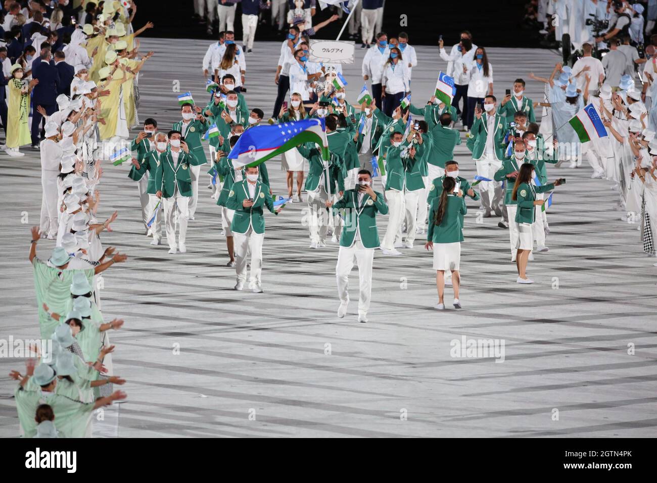 23 LUGLIO 2021 - TOKYO, GIAPPONE: I portieri di bandiera uzbekistan Oksana Chusovitina e Bobo-Usmon Baturov entrano nello Stadio Olimpico con la loro delegazione du Foto Stock