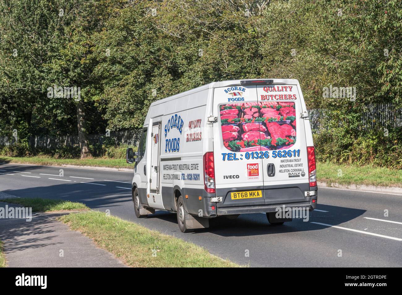 Scorce macellaio locale IVECO consegna furgone in discesa su strada di campagna. Per la mancanza di autista nel Regno Unito, consegna di cibo durante il trasporto di Covid, Regno Unito. Foto Stock